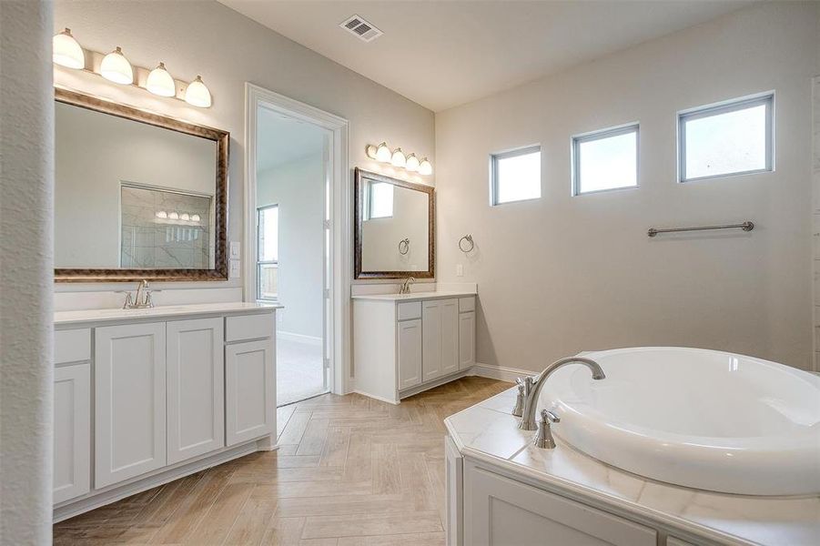 Bathroom featuring a bath and double sink vanity