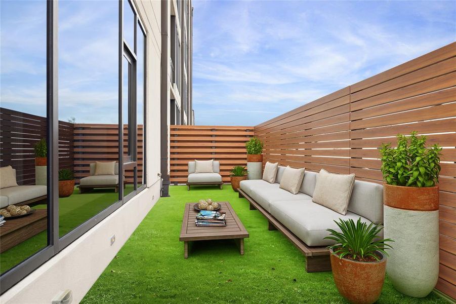 This staged photo showcases a modern upgraded terrace with a stylish wooden privacy fence, pet-friendly artificial grass, and contemporary outdoor furniture.  Perfect for relaxation and entertaining.