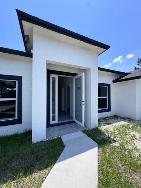 Front exterior of a new home in , Palm Bay, FL, highlighting curb appeal (Image 2).