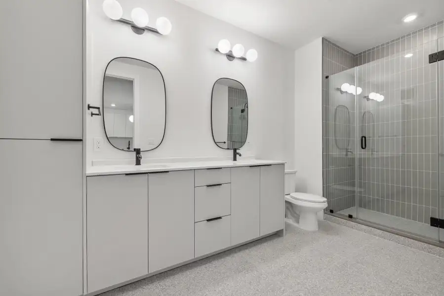 Full bath featuring double vanity and a shower stall