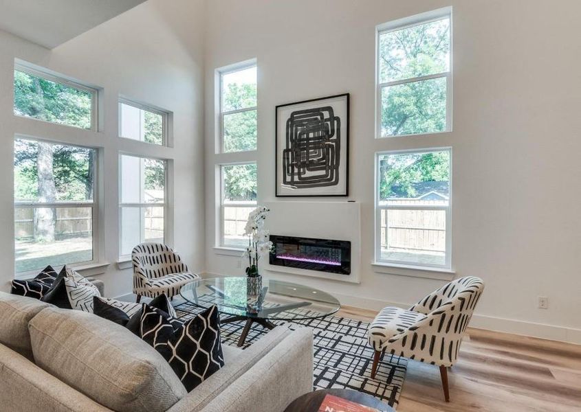 Living room featuring hardwood / wood-style flooring, plenty of natural light, and a high ceiling