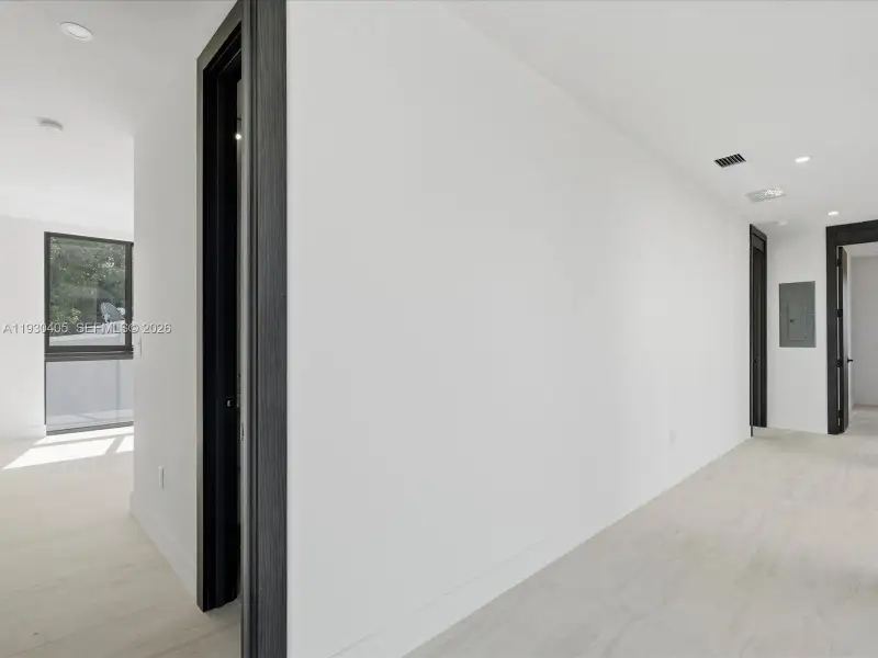 Interior space featuring wood-finish flooring, recessed lighting, and bold dark-toned door casings Interior space featuring wood-finish flooring, recessed lighting, and bold dark-toned door casings