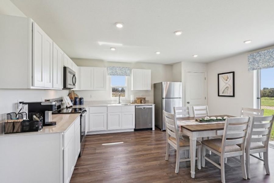 A kitchen with white cabinets.