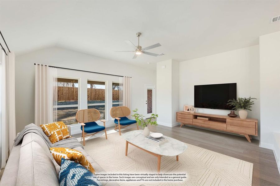Living room with vaulted ceiling, ceiling fan, hardwood floors, and large windows overlooking backyard