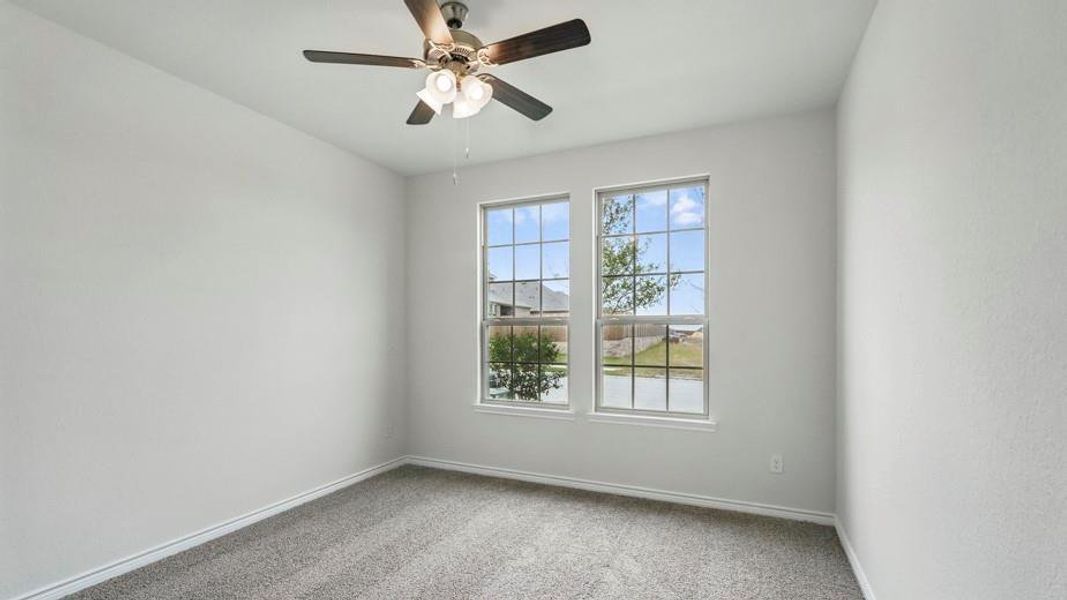 Unfurnished room featuring light carpet and a ceiling fan