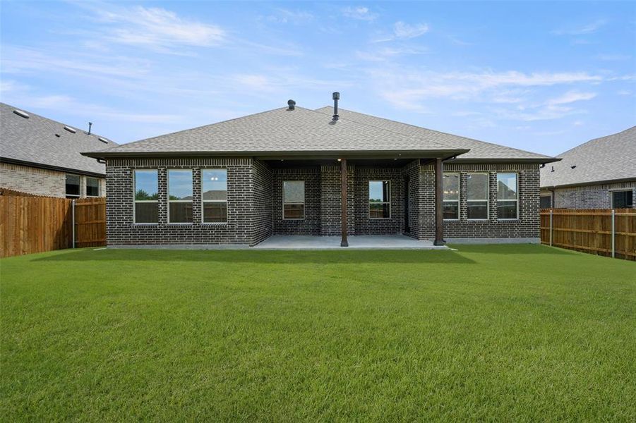 Rear view of property featuring brick siding, a fenced backyard, a patio, and roof with shingles Rear view of property featuring brick siding, a fenced backyard, a patio, and roof with shingles