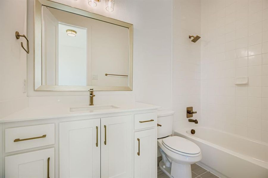 Full bathroom with vanity, tub / shower combination, and tile patterned flooring Full bathroom with vanity, tub / shower combination, and tile patterned flooring