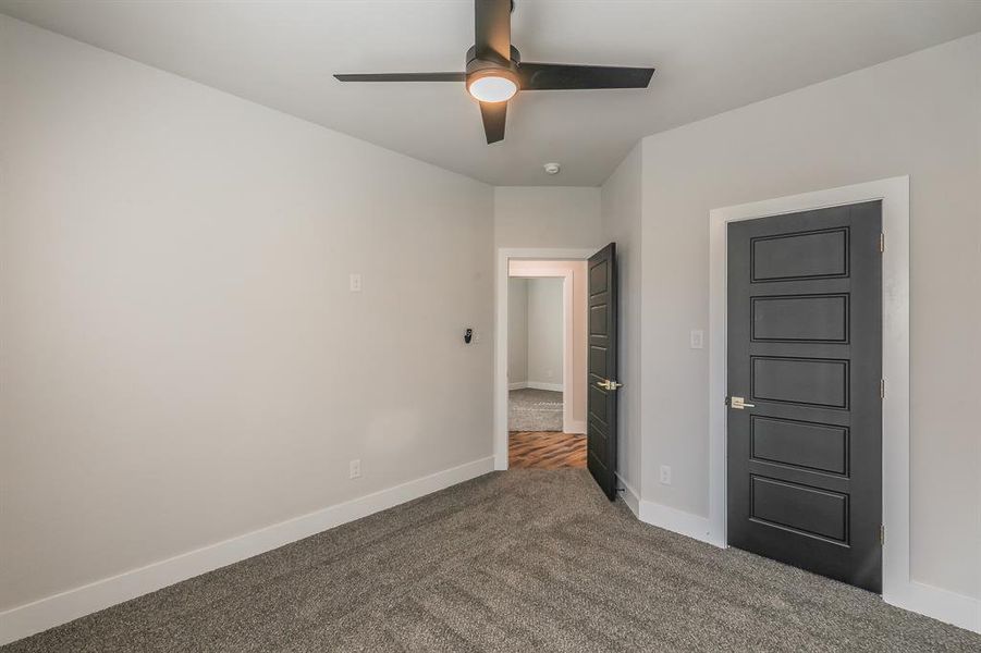 Carpeted spare room featuring ceiling fan