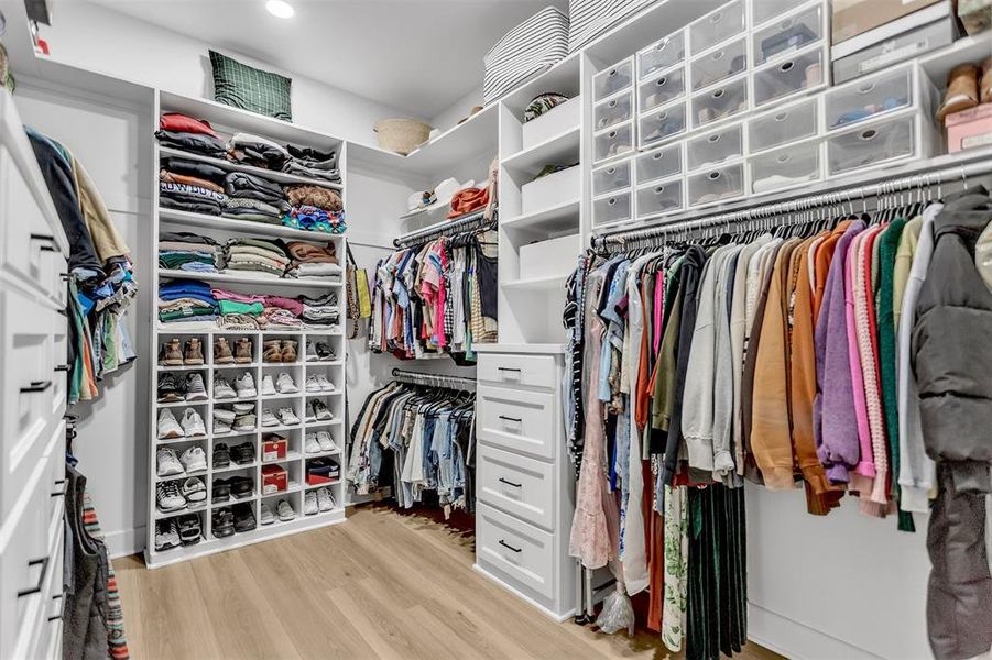 Spacious primary walk in closet featuring with an abundance of custom storage solutions. Spacious primary walk in closet featuring with an abundance of custom storage solutions.