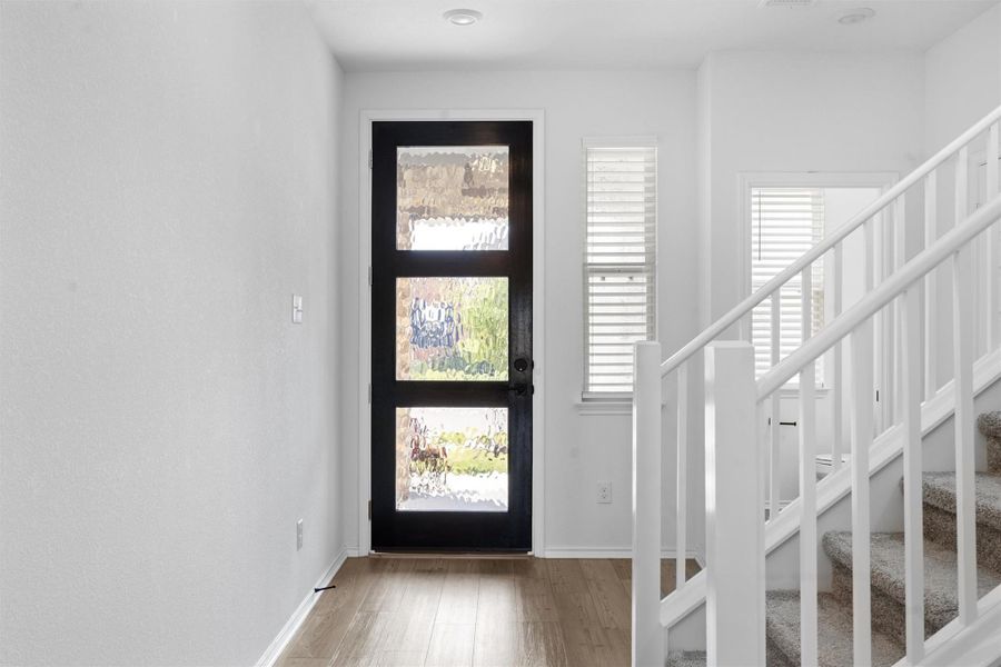 Foyer featuring stairs and light wood-type flooring