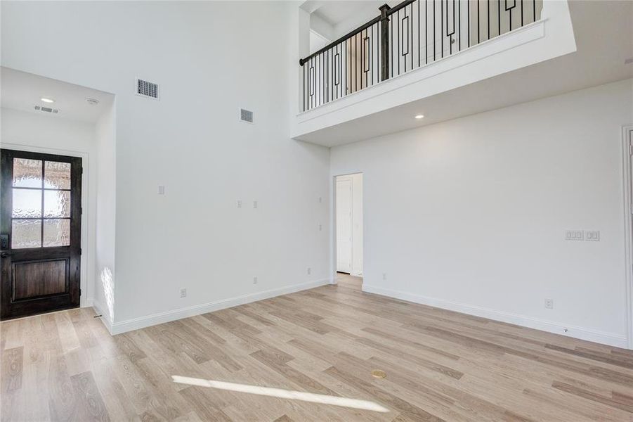 Entrance foyer featuring a high ceiling and light hardwood / wood-style flooring