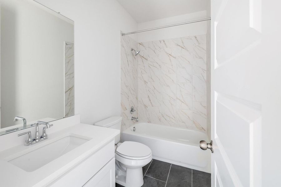 Full bath featuring toilet, tub / shower combination, tile patterned flooring, and vanity Full bath featuring toilet, tub / shower combination, tile patterned flooring, and vanity