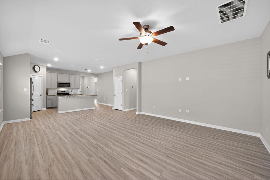 Unfurnished living room featuring ceiling fan, light wood-style floors, and recessed lighting