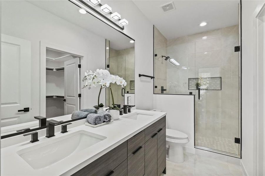 Bathroom with walk in shower, vanity, toilet, and tile patterned floors