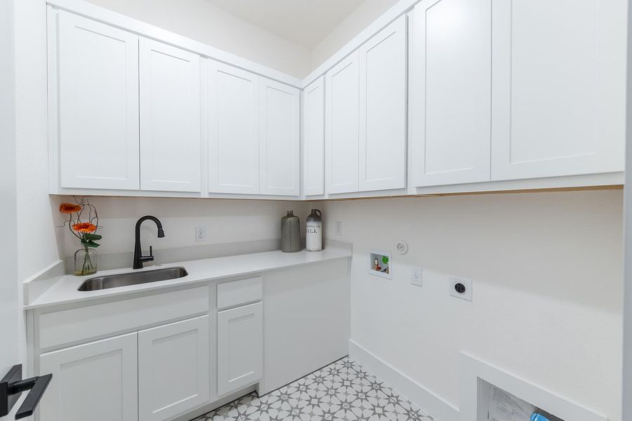 Laundry room with sink, ample built in Kent Moore cabinets, washer and dryer hookup