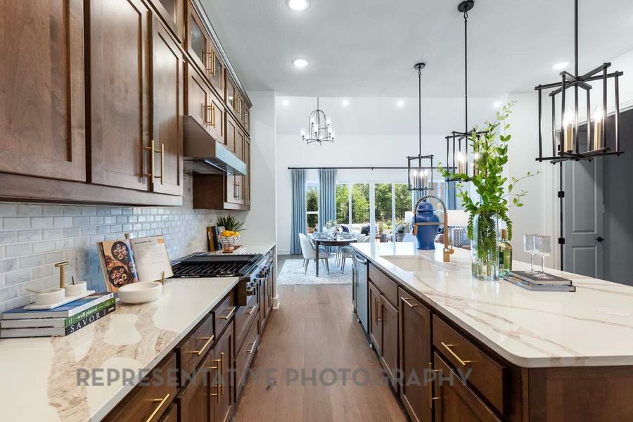 Kitchen featuring dark brown cabinetry, light stone countertops, a large island, glass insert cabinets, and dark wood-type flooring