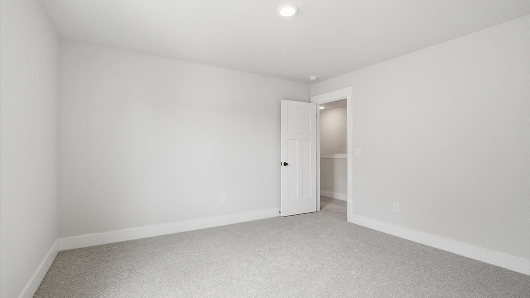 Functional space offering plush carpet underfoot and a thoughtfully planned walk-in closet