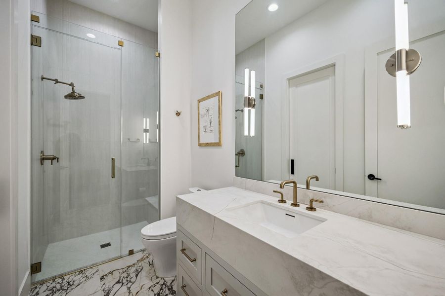 This beautifully appointed bathroom serves both the main level and the home office, offering the flexibility for the office to function as a first-floor fifth bedroom.