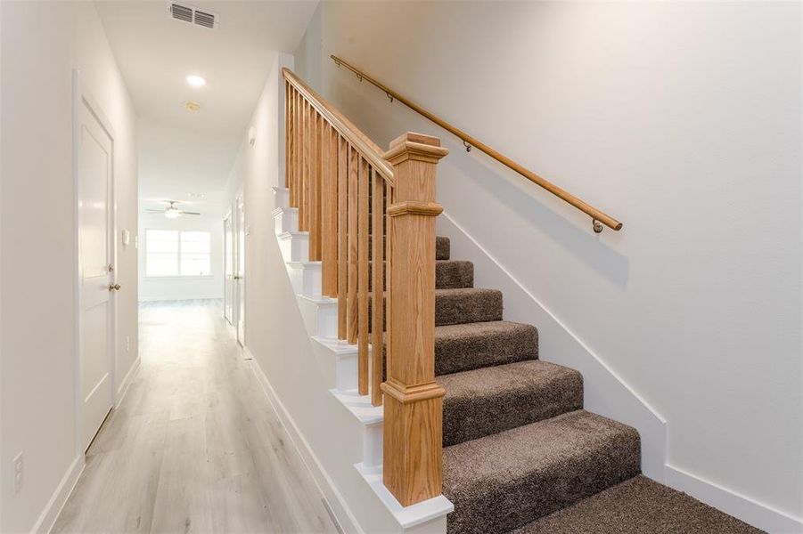 Stairs with ceiling fan and light wood-type flooring