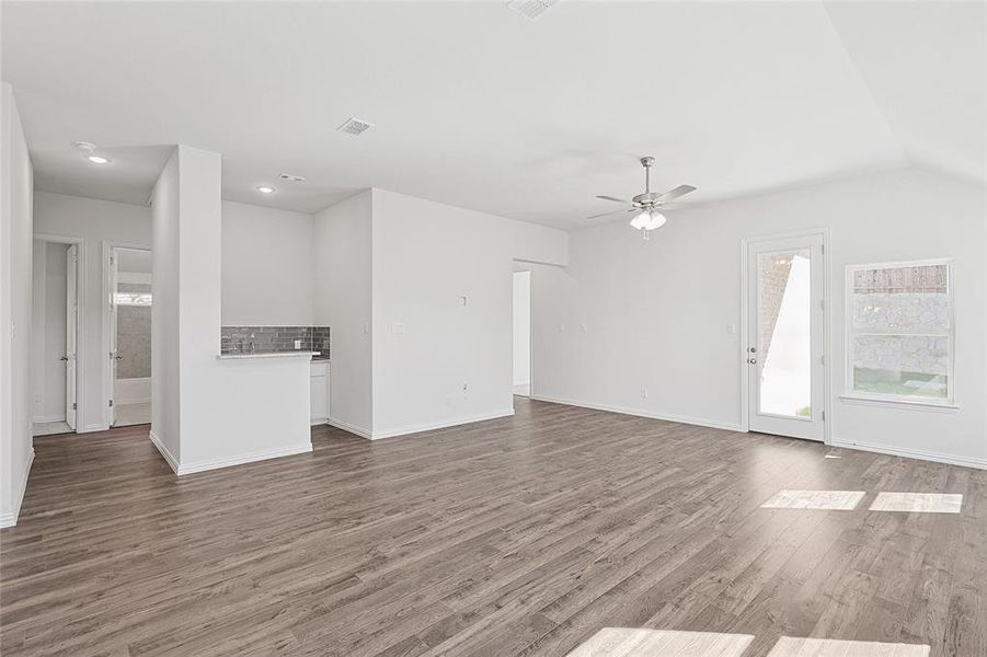 Unfurnished living room with ceiling fan, lofted ceiling, and hardwood / wood-style flooring