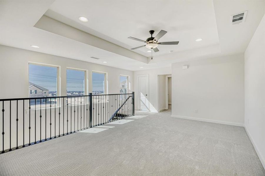 Spare room featuring light carpet, a ceiling fan, a raised ceiling, and recessed lighting