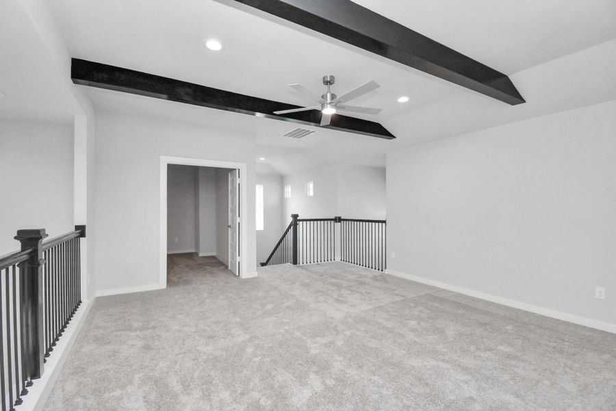 Ascend to relaxation in this fantastic game room! Ideal for both casual gatherings and adult gaming, it boasts plush carpet, lofty ceilings, custom paint, and ample windows for abundant natural light. Sample photo of completed home with similar floor plan. Actual colors and selections may vary.