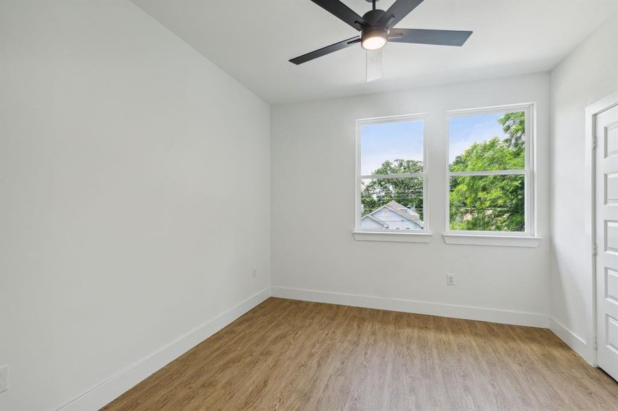 Unfurnished room featuring a wealth of natural light, light wood-type flooring, and ceiling fan