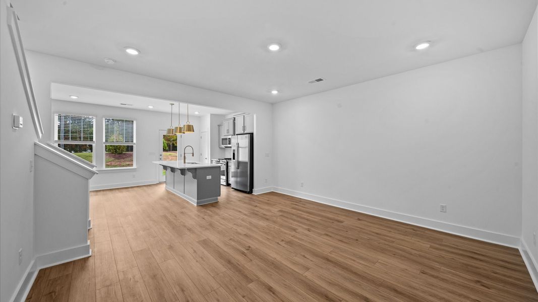 Spacious family room with rich hardwood flooring and elegant trim work in a reputable DRB Homes build at Ransdell Pointe
