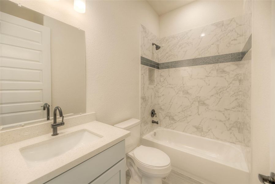 #2 Modern bathroom with a clean, bright design featuring a white vanity, sleek black fixtures, and a bathtub with elegant marble-patterned tiles.