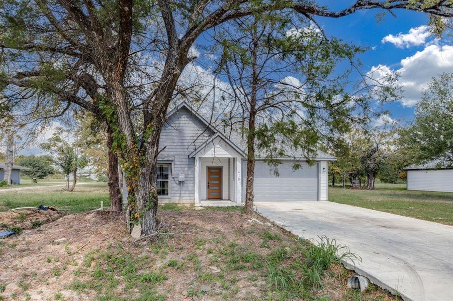 View of front facade featuring concrete driveway and a garage View of front facade featuring concrete driveway and a garage