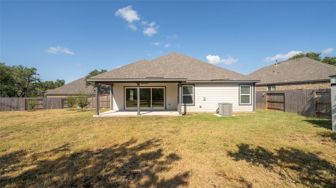 Back of house with a patio area, a shingled roof, a fenced backyard, and ceiling fan Back of house with a patio area, a shingled roof, a fenced backyard, and ceiling fan