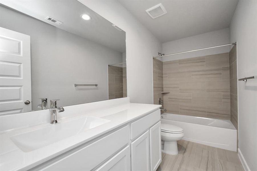 Secondary bathroom equipped with shower/tub combo.