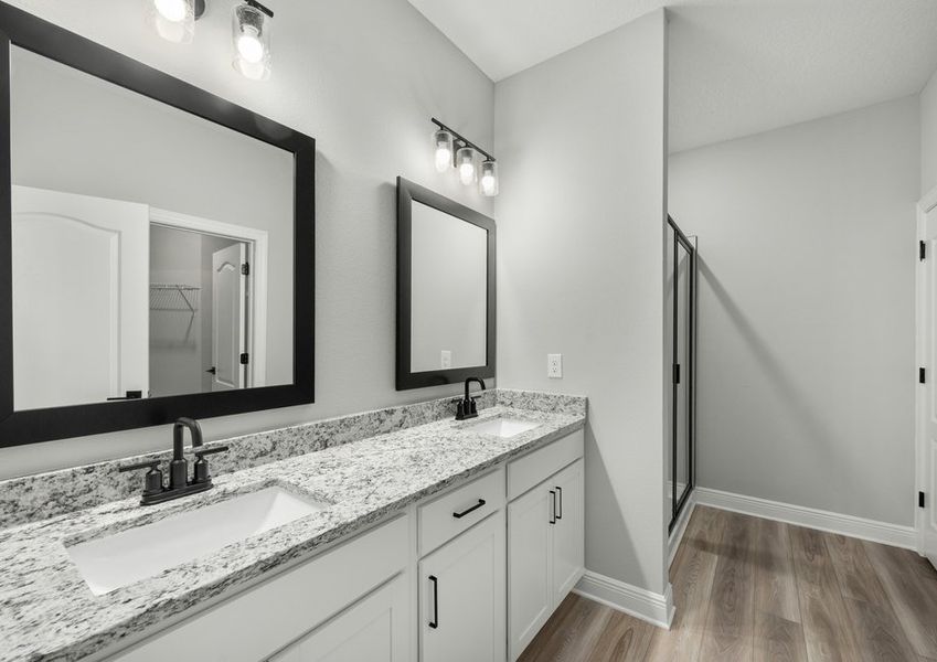 Master bathroom with a dual sink vanity and step-in shower