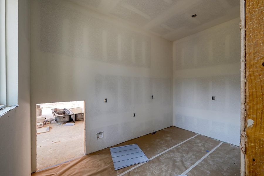 Walk in, working pantry with ample storage with custom cabinetry, a grocery door for easy unloading from the garage and space for an additional fridge.