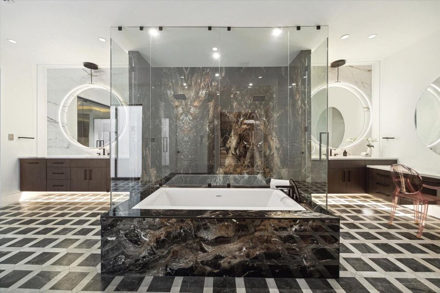 Taking center stage in the primary bathroom and commanding attention is a luxurious alcove, under-mount tub and a spacious glass inclosed double entry walk in shower.