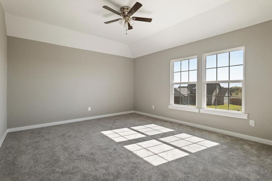 Carpeted empty room with ceiling fan and lofted ceiling Carpeted empty room with ceiling fan and lofted ceiling