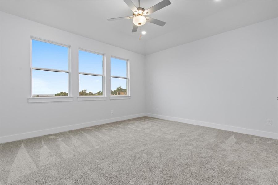 Carpeted empty room with ceiling fan