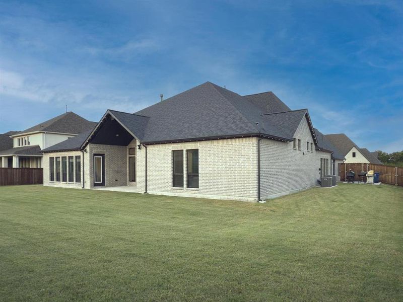 Rear view of house featuring a patio, brick siding, and a shingled roof Rear view of house featuring a patio, brick siding, and a shingled roof