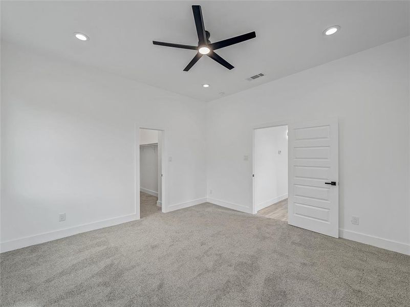 Carpeted spare room featuring ceiling fan