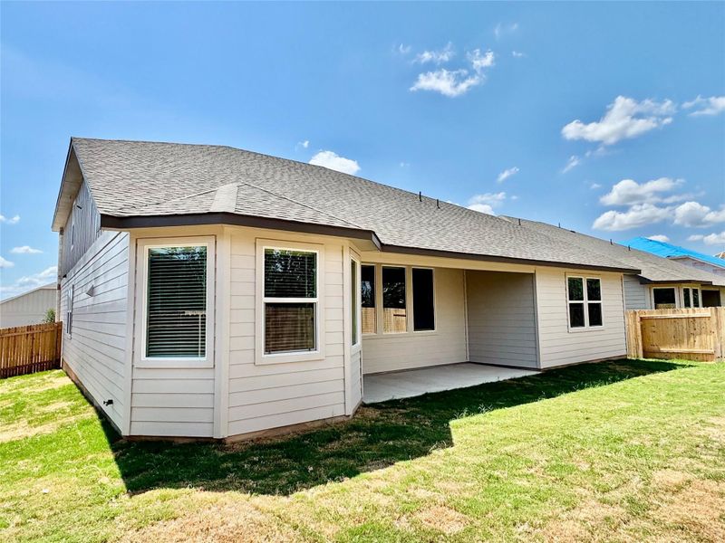 Rear view of property with a patio and a shingled roof Rear view of property with a patio and a shingled roof