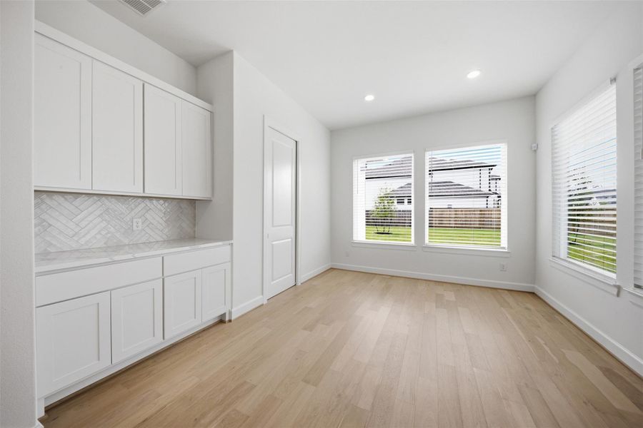 Bright and airy dining space conveniently located adjacent to the kitchen with abundant natural light and built-in serving cabinetry.