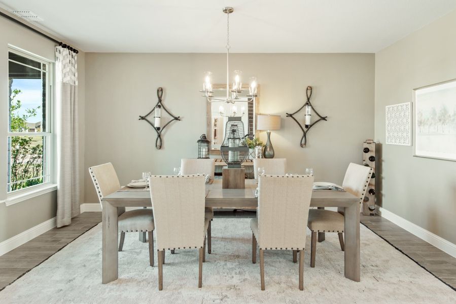 Dining room with six-seat wooden table, chandelier, and neutral decor on hardwood floors