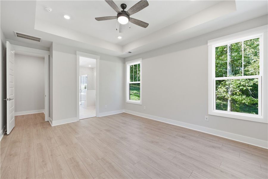 Clean lines and a tray ceiling define this light-f