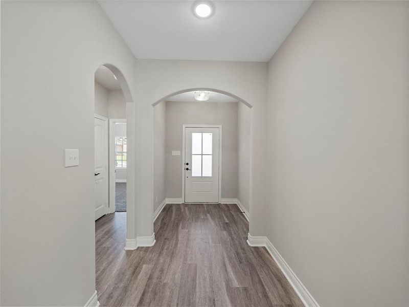 Entryway featuring arched walkways and wood finished floors Entryway featuring arched walkways and wood finished floors
