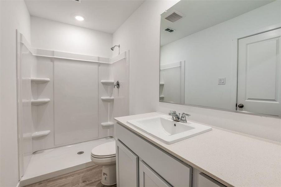 Bathroom featuring walk in shower, wood-type flooring, toilet, and vanity