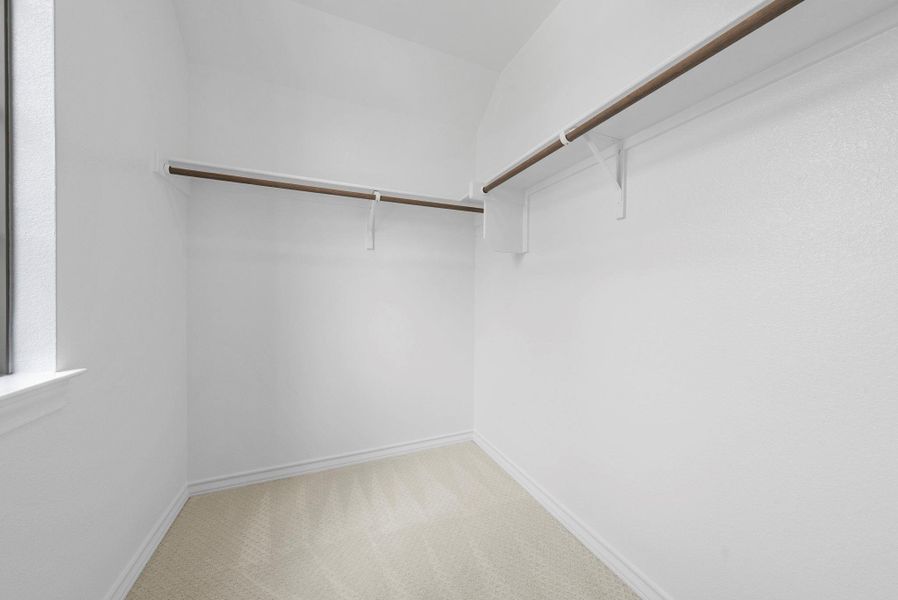 Walk-in closet with ample hanging space and room for customization.