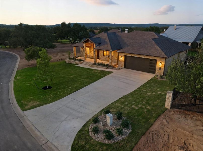 View of front of house with stone siding, concrete driveway, a yard, a garage, and a porch View of front of house with stone siding, concrete driveway, a yard, a garage, and a porch