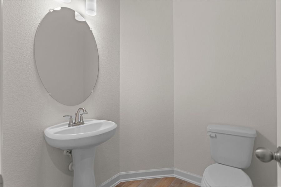 This charming half bath features a classic pedestal sink and clean finishes, perfect for guests, offering convenience and style tucked neatly off the main living areas.