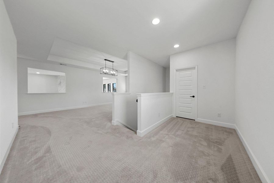 Empty room featuring recessed lighting, light carpet, a notable chandelier, and baseboards