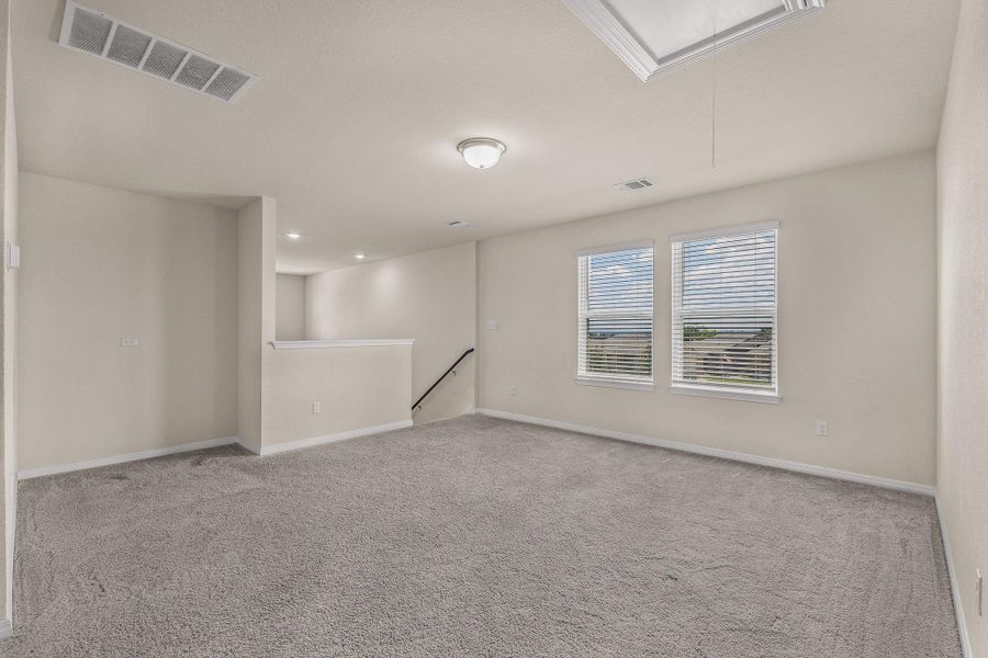 Unfurnished room with attic access and light colored carpet Unfurnished room with attic access and light colored carpet